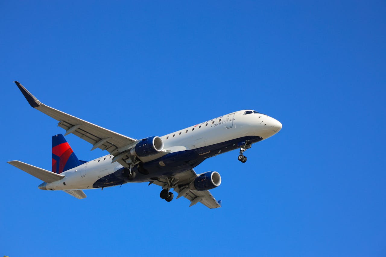 Airplane mid-flight beneath a clear blue sky, showcasing aviation technologies.